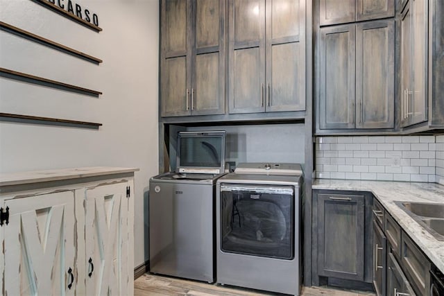 8960 N Banner Rd, Yukon, OK 73099 - laundry room featuring cabinet space, washer and dryer, and light wood-type flooring