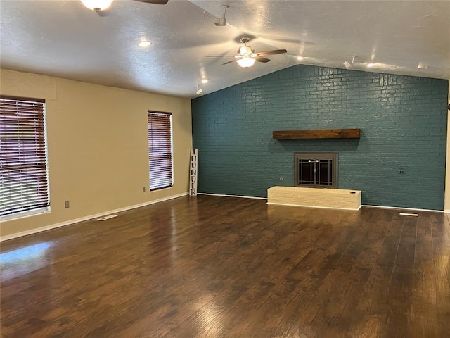9105 Oak Creek Dr, Midwest City, OK 73130 - unfurnished living room with a ceiling fan, lofted ceiling, a brick fireplace, wood finished floors, and brick wall