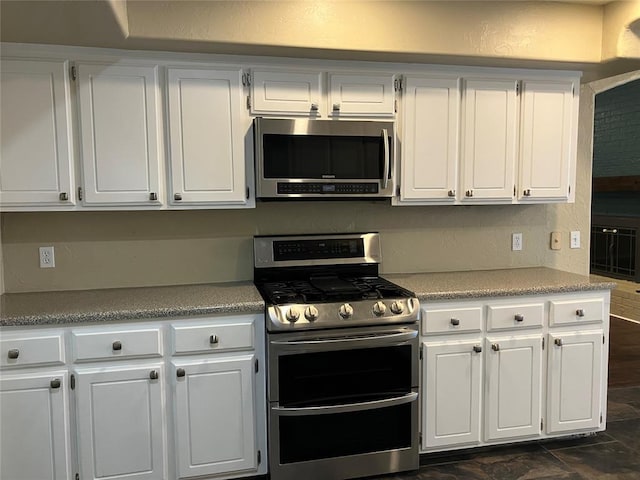 9105 Oak Creek Dr, Midwest City, OK 73130 - kitchen with appliances with stainless steel finishes, white cabinets, and light countertops