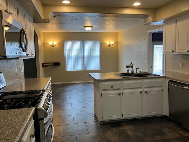 9105 Oak Creek Dr, Midwest City, OK 73130 - kitchen with appliances with stainless steel finishes, white cabinets, healthy amount of natural light, a peninsula, and recessed lighting