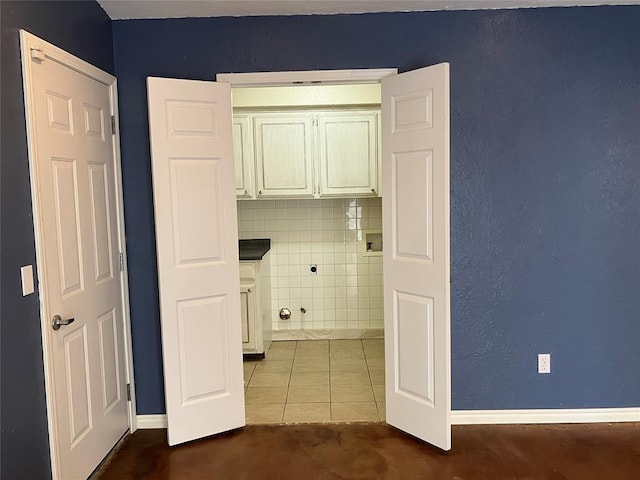 9105 Oak Creek Dr, Midwest City, OK 73130 - laundry area with hookup for a washing machine, cabinet space, and dark tile patterned flooring