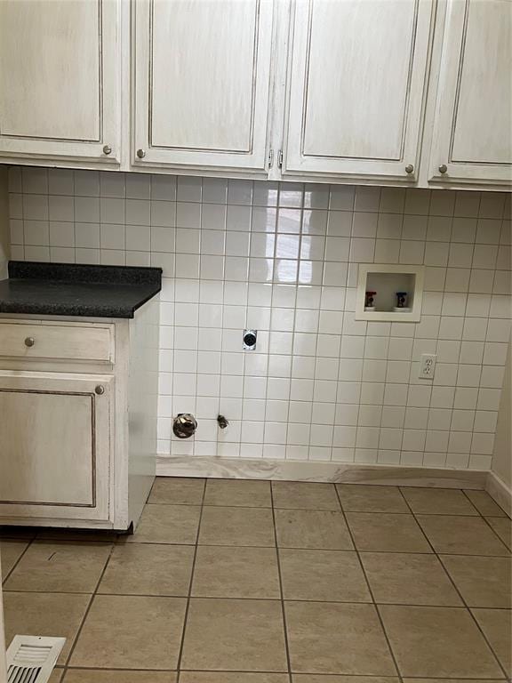 9105 Oak Creek Dr, Midwest City, OK 73130 - laundry area with washer hookup, tile patterned floors, and cabinet space