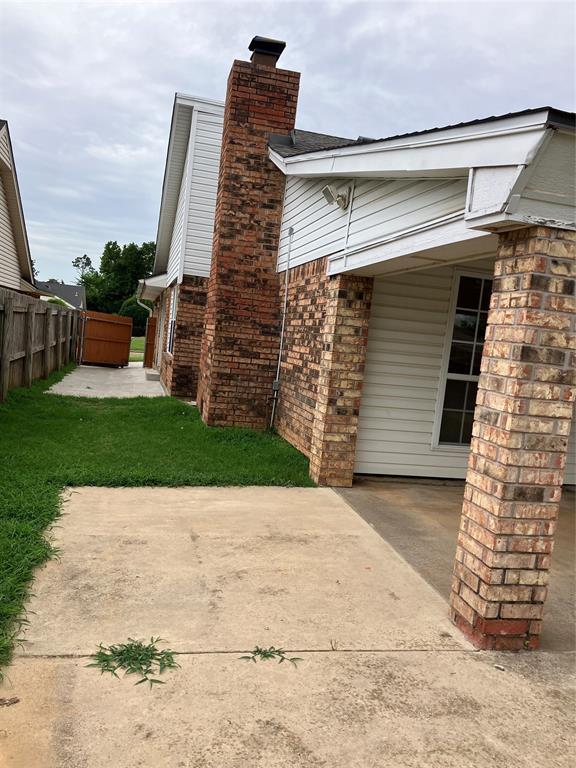 9105 Oak Creek Dr, Midwest City, OK 73130 - view of side of property featuring a chimney, a patio area, and brick siding