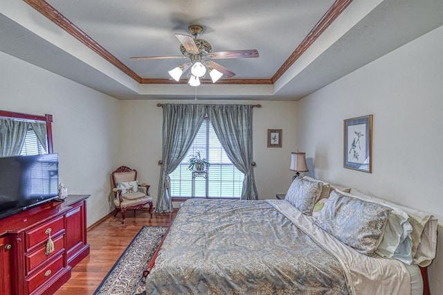 645 SW 160th St, Oklahoma City, OK 73170 - bedroom featuring a tray ceiling, crown molding, multiple windows, wood finished floors, and a ceiling fan