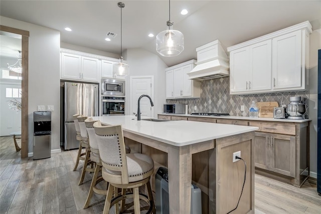 14812 Deerbrook Blvd, Oklahoma City, OK 73142 - kitchen with stainless steel appliances, premium range hood, decorative backsplash, light wood-style flooring, and lofted ceiling
