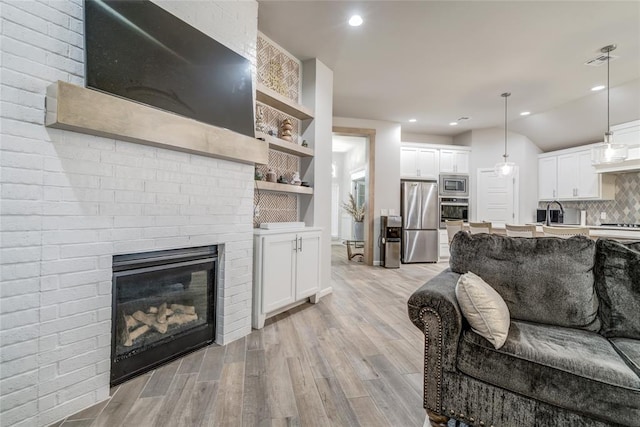 14812 Deerbrook Blvd, Oklahoma City, OK 73142 - living room featuring light wood finished floors, recessed lighting, and a fireplace