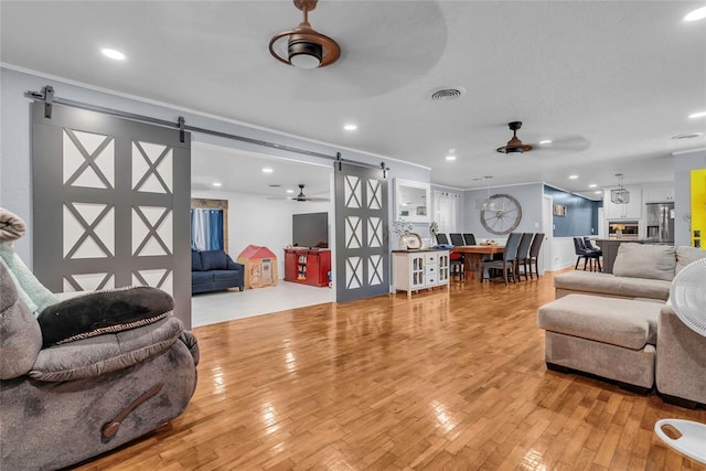 1800 SW 6th St, Ardmore, OK 73401 - living area featuring a barn door, ceiling fan, light wood finished floors, recessed lighting, and crown molding