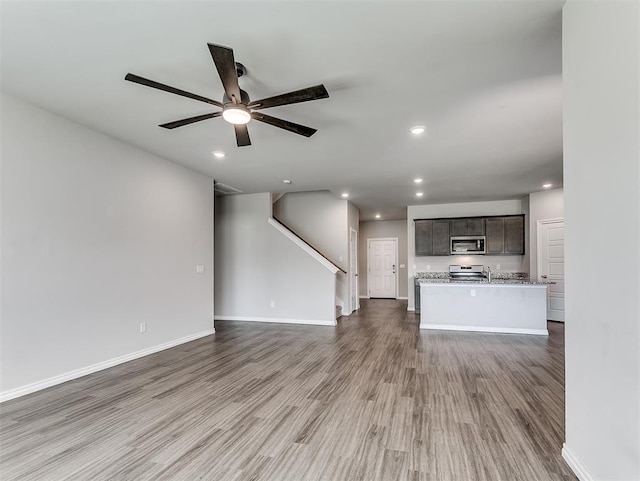 4205 Palmetto Bluff Dr, Mustang, OK 73064 - unfurnished living room featuring wood finished floors, a ceiling fan, recessed lighting, and stairway
