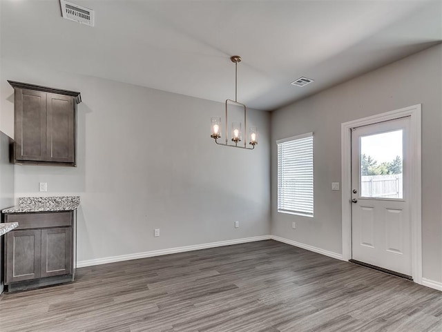 4205 Palmetto Bluff Dr, Mustang, OK 73064 - unfurnished dining area with wood finished floors and a chandelier
