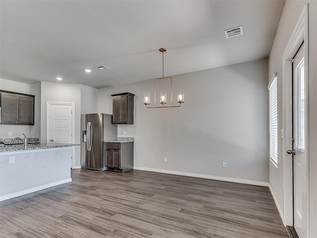 4205 Palmetto Bluff Dr, Mustang, OK 73064 - kitchen with stainless steel refrigerator with ice dispenser, dark brown cabinetry, a chandelier, dark wood-style flooring, and recessed lighting