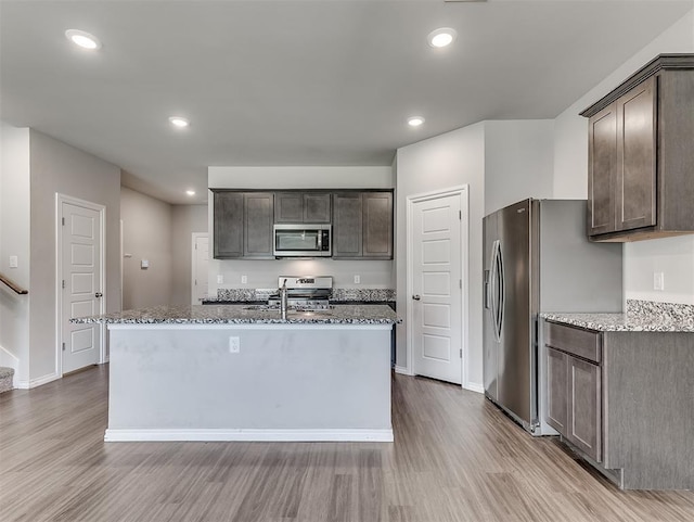 4205 Palmetto Bluff Dr, Mustang, OK 73064 - kitchen with stainless steel appliances, wood finished floors, dark brown cabinets, stone counters, and recessed lighting