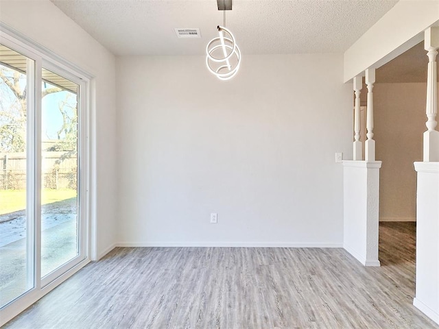4713 Meench Dr, Del City, OK 73115 - spare room featuring light wood-style flooring, healthy amount of natural light, and a textured ceiling