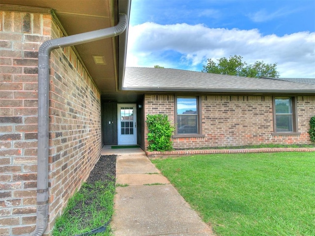 17 Pueblo, Edmond, OK 73013 - property entrance with brick siding, a yard, and roof with shingles