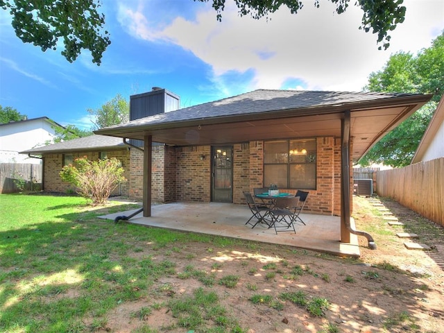 17 Pueblo, Edmond, OK 73013 - back of house featuring a patio area, brick siding, a fenced backyard, and a chimney