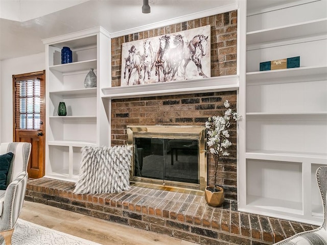 17 Pueblo, Edmond, OK 73013 - unfurnished living room with a brick fireplace and wood finished floors