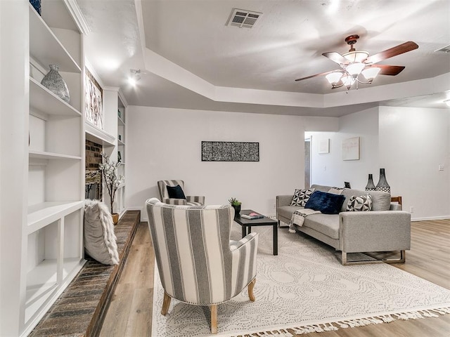 17 Pueblo, Edmond, OK 73013 - living room featuring wood finished floors, ceiling fan, and a tray ceiling