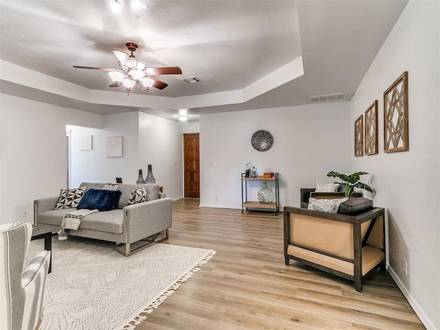 17 Pueblo, Edmond, OK 73013 - living area with a ceiling fan, light wood-style floors, and a tray ceiling