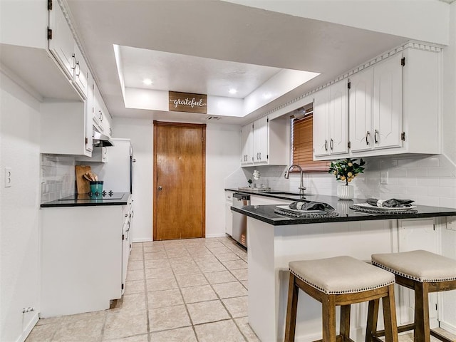 17 Pueblo, Edmond, OK 73013 - kitchen with a raised ceiling, a peninsula, decorative backsplash, stainless steel dishwasher, and recessed lighting