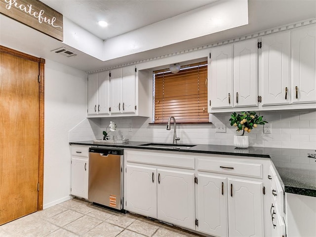 17 Pueblo, Edmond, OK 73013 - kitchen with dishwasher, dark countertops, decorative backsplash, white cabinets, and light tile patterned floors