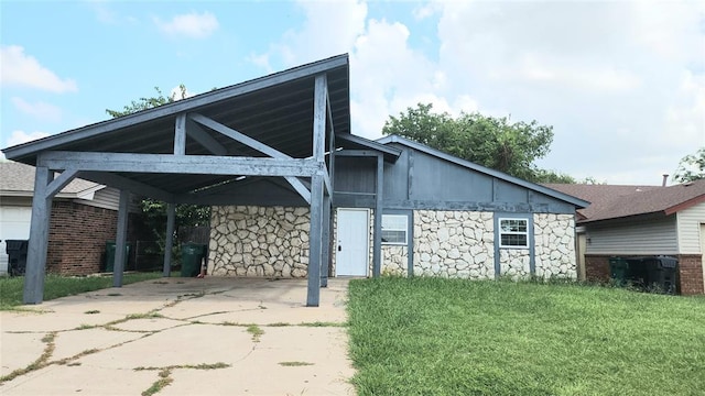 537 NW 114th St, Oklahoma City, OK 73114 - view of front of property featuring stone siding, driveway, a front lawn, and a carport