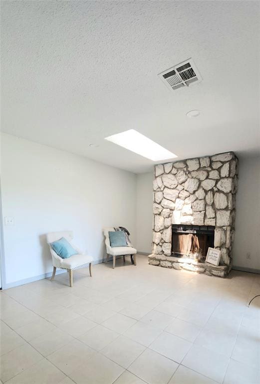 537 NW 114th St, Oklahoma City, OK 73114 - unfurnished room with a fireplace, tile patterned floors, a textured ceiling, and a skylight