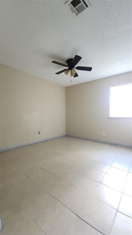 537 NW 114th St, Oklahoma City, OK 73114 - empty room with a textured ceiling, a ceiling fan, and light tile patterned floors