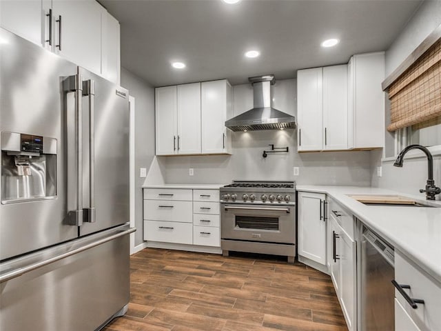 320 N Jasper Way, Mustang, OK 73064 - kitchen featuring premium appliances, wall chimney exhaust hood, light countertops, white cabinetry, and recessed lighting