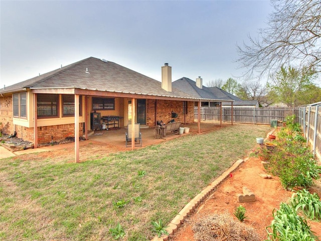 320 N Jasper Way, Mustang, OK 73064 - rear view of property featuring a chimney, a fenced backyard, a patio, brick siding, and roof with shingles
