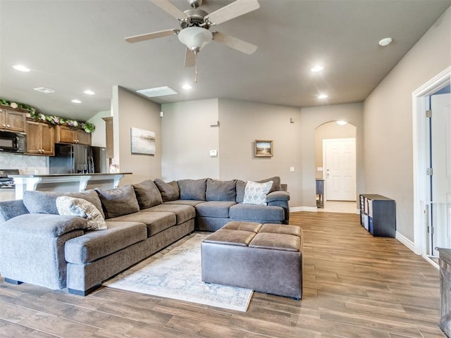 8025 Waters Edge Way, Del City, OK 73135 - living area featuring arched walkways, light wood-type flooring, a ceiling fan, and recessed lighting