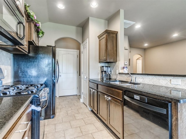 8025 Waters Edge Way, Del City, OK 73135 - kitchen with black appliances, arched walkways, decorative backsplash, dark stone counters, and light tile patterned floors