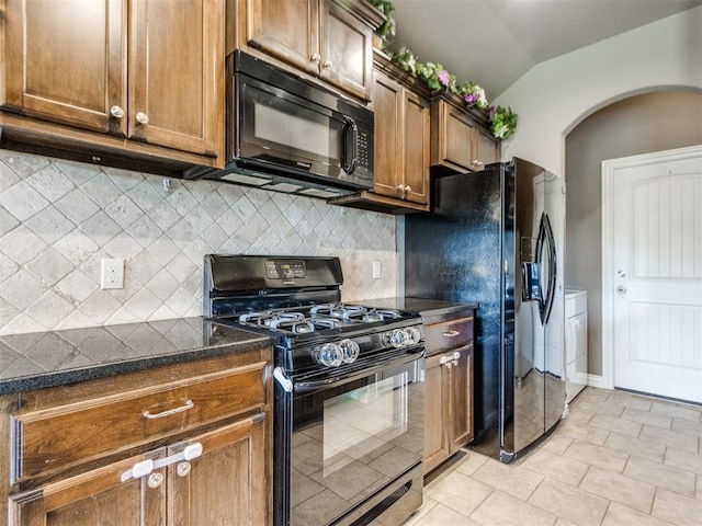 8025 Waters Edge Way, Del City, OK 73135 - kitchen with black appliances, arched walkways, washing machine and dryer, backsplash, and lofted ceiling