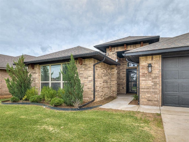 11604 SW 9th St, Yukon, OK 73099 - view of front of home featuring brick siding, a front lawn, an attached garage, and a shingled roof