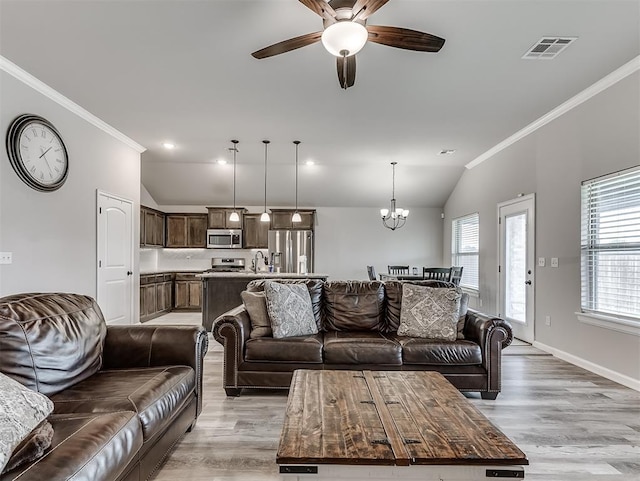 11604 SW 9th St, Yukon, OK 73099 - living area with lofted ceiling, ornamental molding, light wood-style flooring, a ceiling fan, and a chandelier