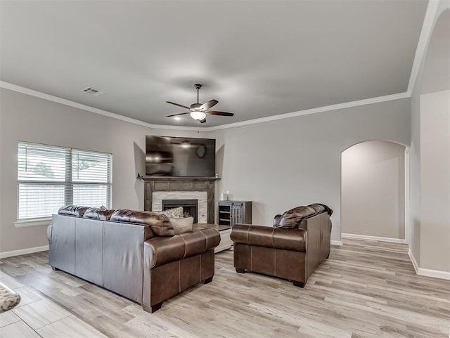 11604 SW 9th St, Yukon, OK 73099 - living area with arched walkways, a ceiling fan, crown molding, light wood finished floors, and a fireplace