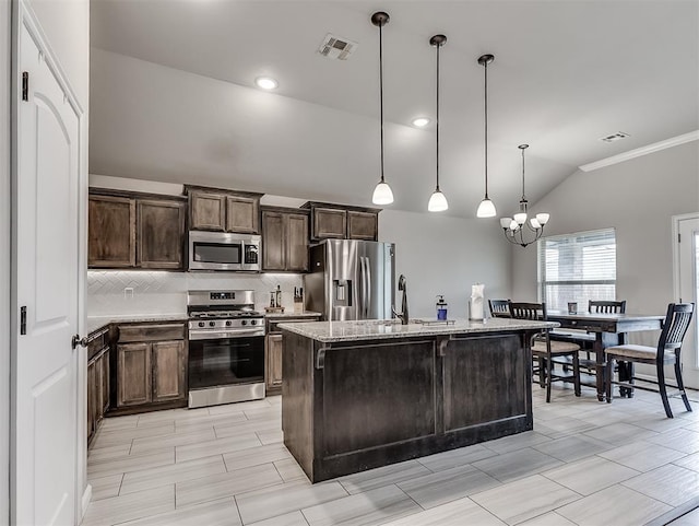 11604 SW 9th St, Yukon, OK 73099 - kitchen with appliances with stainless steel finishes, vaulted ceiling, tasteful backsplash, a chandelier, and dark brown cabinets