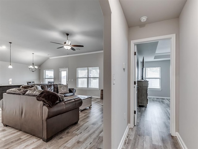 11604 SW 9th St, Yukon, OK 73099 - living room with light wood-type flooring, ceiling fan, a chandelier, vaulted ceiling, and arched walkways