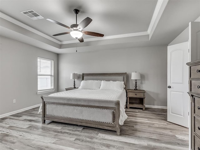 11604 SW 9th St, Yukon, OK 73099 - bedroom featuring a raised ceiling, ornamental molding, light wood-type flooring, and a ceiling fan