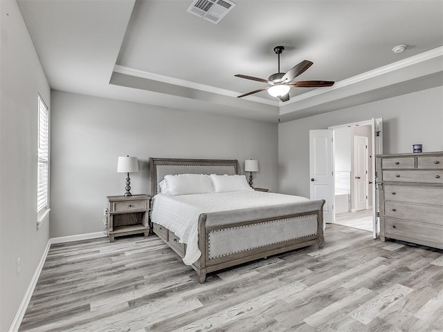 11604 SW 9th St, Yukon, OK 73099 - bedroom featuring a tray ceiling, light wood finished floors, crown molding, and a ceiling fan