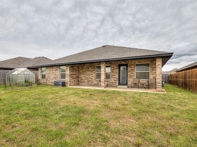 11604 SW 9th St, Yukon, OK 73099 - rear view of property featuring a greenhouse, a fenced backyard, a patio area, an outbuilding, and roof with shingles