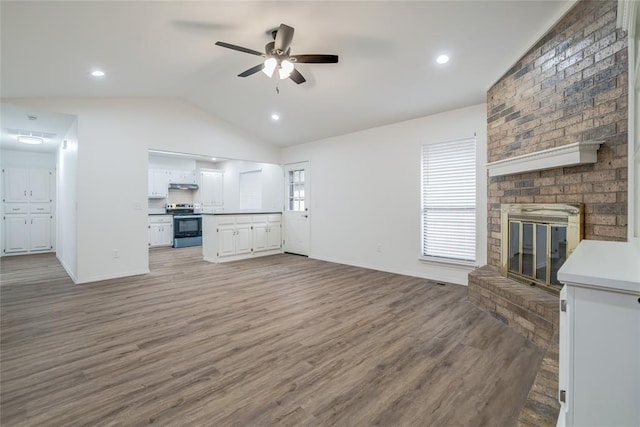 7913 Debar Cir, Oklahoma City, OK 73132 - unfurnished living room with lofted ceiling, a ceiling fan, light wood finished floors, and a fireplace