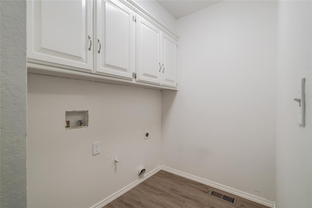 7913 Debar Cir, Oklahoma City, OK 73132 - laundry area featuring hookup for an electric dryer, cabinet space, wood finished floors, and washer hookup