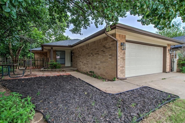 7913 Debar Cir, Oklahoma City, OK 73132 - view of home's exterior with a garage, brick siding, concrete driveway, covered porch, and a shingled roof