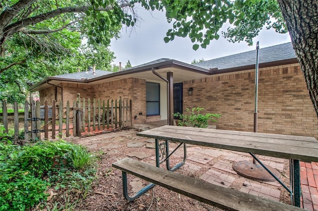 7913 Debar Cir, Oklahoma City, OK 73132 - rear view of property featuring brick siding, a patio, and a shingled roof