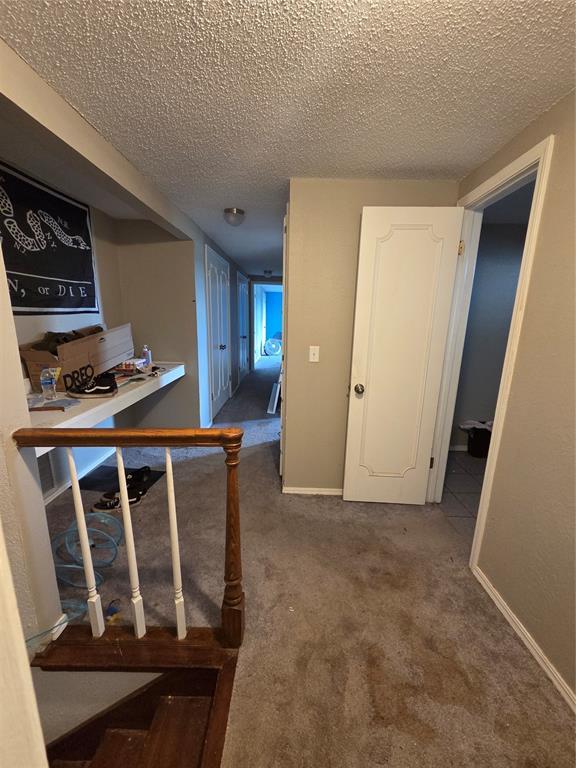 5621 NW 83rd St, Oklahoma City, OK 73132 - hallway featuring a textured ceiling and carpet flooring