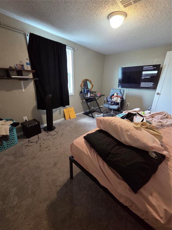 5621 NW 83rd St, Oklahoma City, OK 73132 - carpeted bedroom featuring a textured ceiling and baseboards