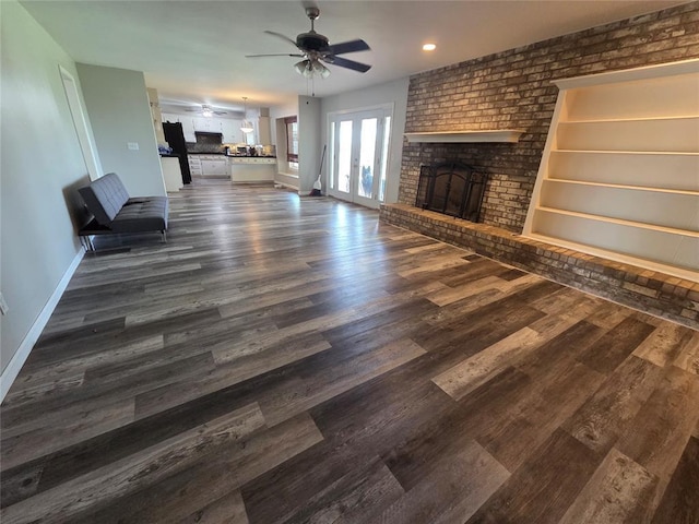 5621 NW 83rd St, Oklahoma City, OK 73132 - unfurnished living room with ceiling fan, a brick fireplace, dark wood-style floors, recessed lighting, and french doors