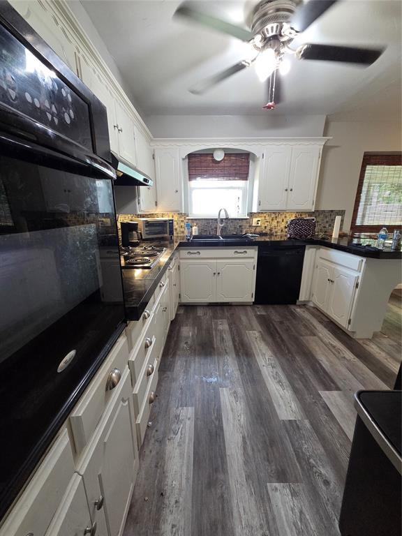 5621 NW 83rd St, Oklahoma City, OK 73132 - kitchen with black appliances, backsplash, dark countertops, and healthy amount of natural light