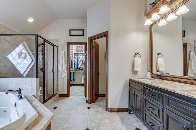 16204 Old Olive Way, Edmond, OK 73013 - full bathroom featuring a whirlpool tub, double vanity, a stall shower, vaulted ceiling, and a spacious closet