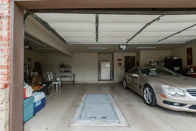 16204 Old Olive Way, Edmond, OK 73013 - garage with freestanding refrigerator, a garage door opener, and electric panel