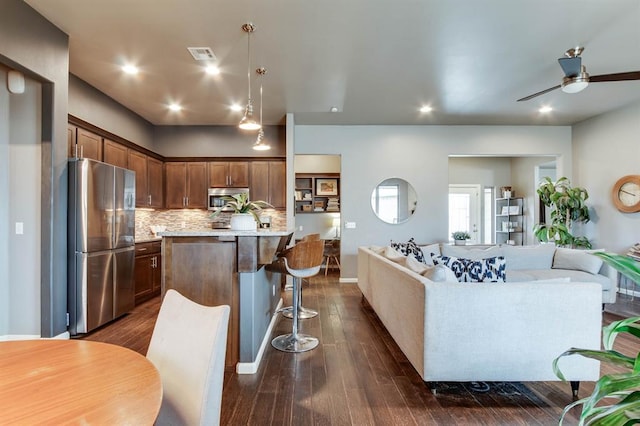 9124 NW 90th Cir, Yukon, OK 73099 - kitchen with appliances with stainless steel finishes, open floor plan, a kitchen bar, backsplash, and ceiling fan